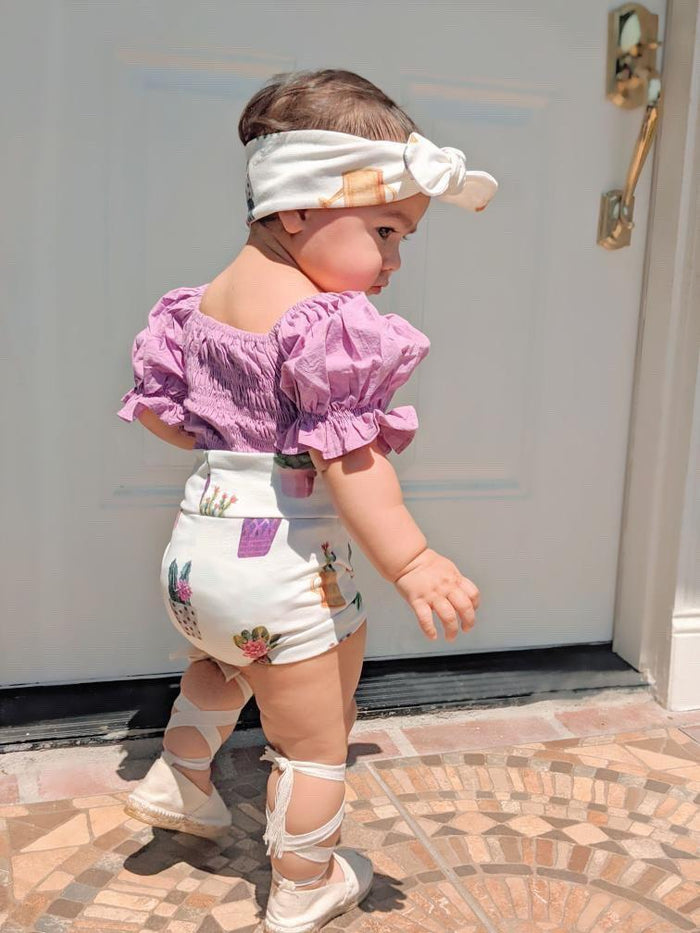 White baby bummies with cute succulent designs, perfect for casual and stylish looks.