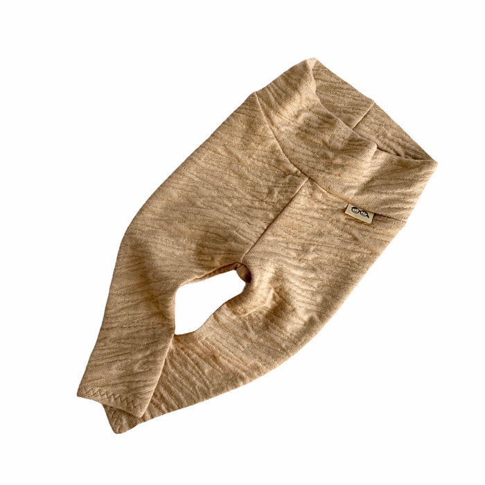 Beige baby pants with a brand logo on a white background