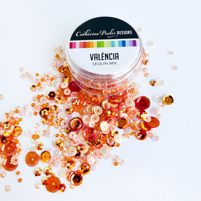 Catherine Pooler - Sequin Mix - Valencia. Add some sparkle in shades of orange with the Valéncia Sequin Mix! This mix was named for Valéncia, Spain and is bright and cheerful. This monochromatic mix and looks great with our Potted Patterned Paper! Approximately 1 Tablespoon mixture packaged in a clear screw top round container. Available at Embellish Away located in Bowmanville Ontario Canada.