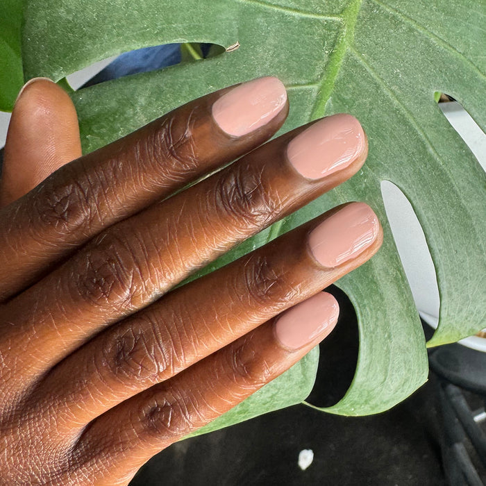 HZ - Gel neutral rosy gel polish manicure on medium-length nails with natural light and green leaf background