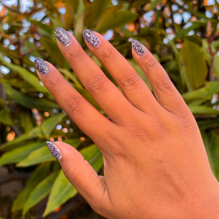 Fingernails coated with Out Past Curfew Gel showing deep flash glitter on blue-black gel polish for a chic mani