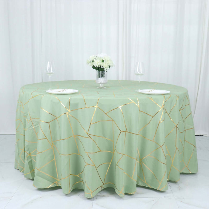 Green tablecloth with gold crackle design on a round table setting.
