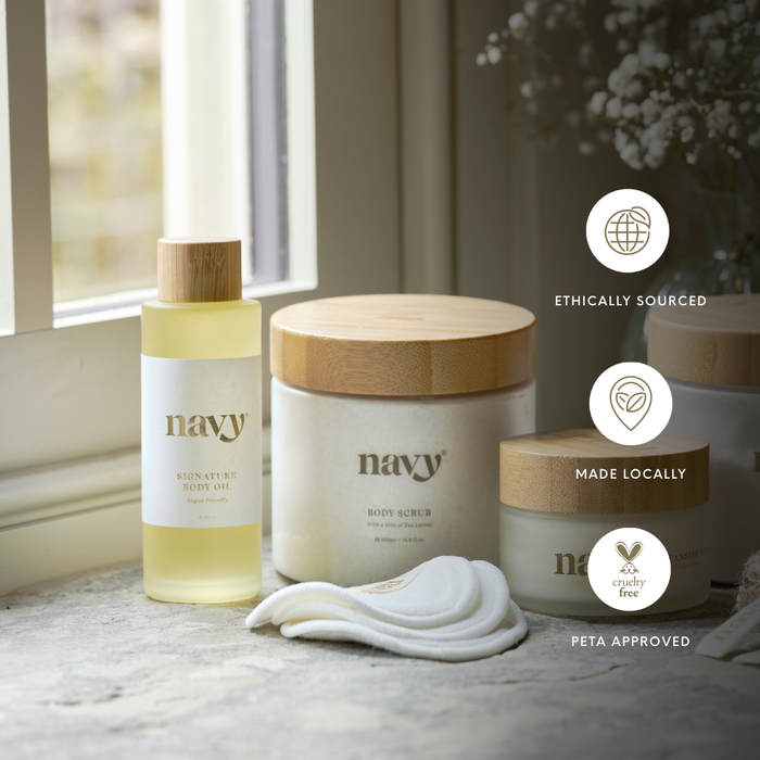 Navy skincare products on a marble surface with a window in the background