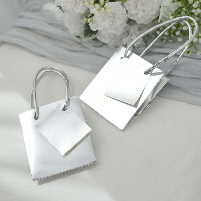 Silver gift bags with blank tags on a soft background.