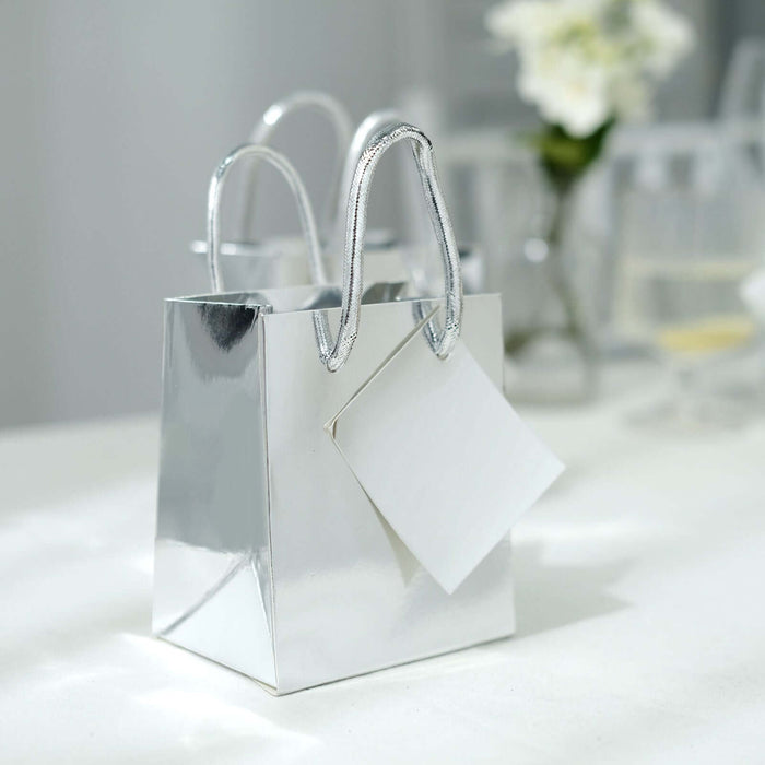 Shiny silver gift bag with a blank tag on a table.