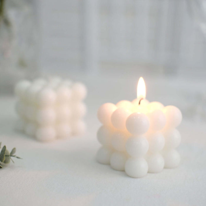 White bubble candle glowing softly on a light surface.