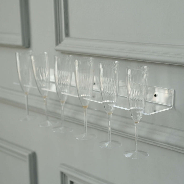 Clear champagne flute rack displaying six elegant glasses.