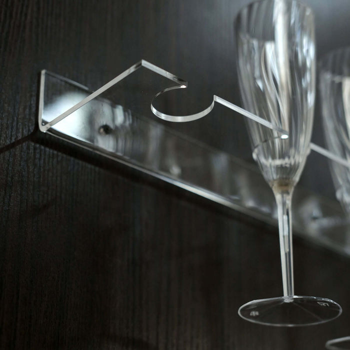Acrylic glass holder with champagne flutes on a sleek black background.