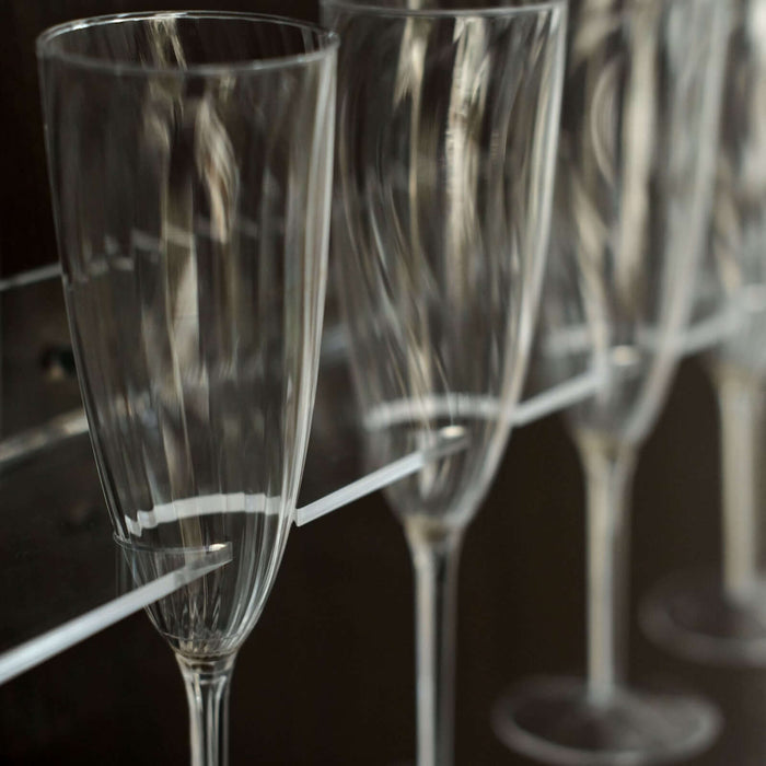 Set of elegant champagne flutes on display in a modern cabinet.