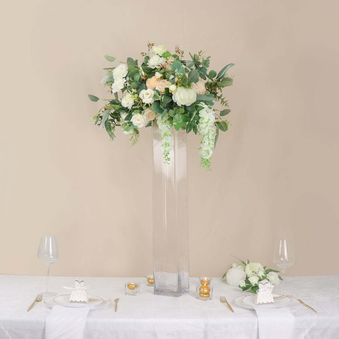 Elegant floral centerpiece in a tall glass vase for event decor.