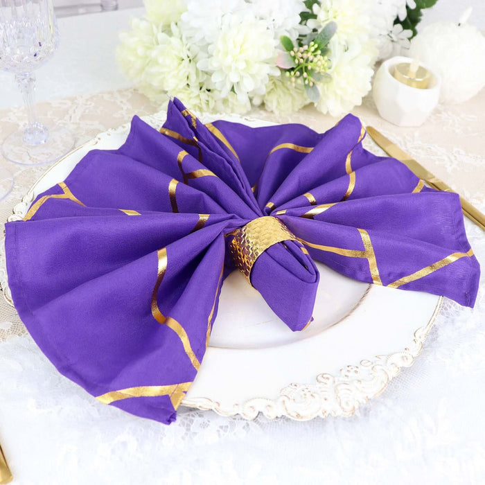 Purple napkin with gold accents elegantly arranged on a white plate.