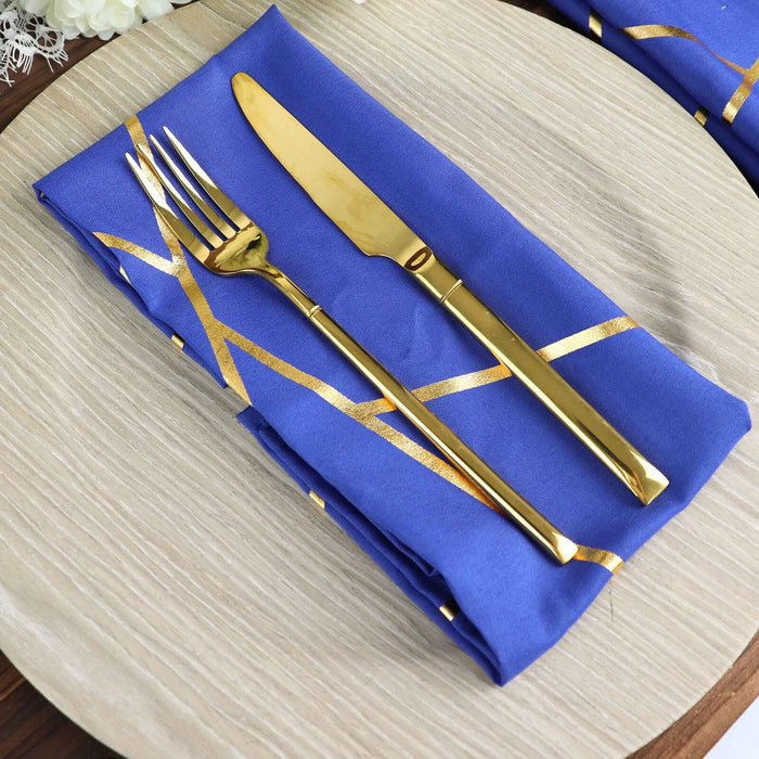 Elegant blue napkin with gold fork and knife on a textured plate.
