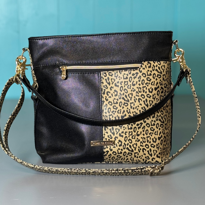 This shoulder bag is made with a textured black vinyl and a leopard print vinyl. It also has a matching crossbody strap.