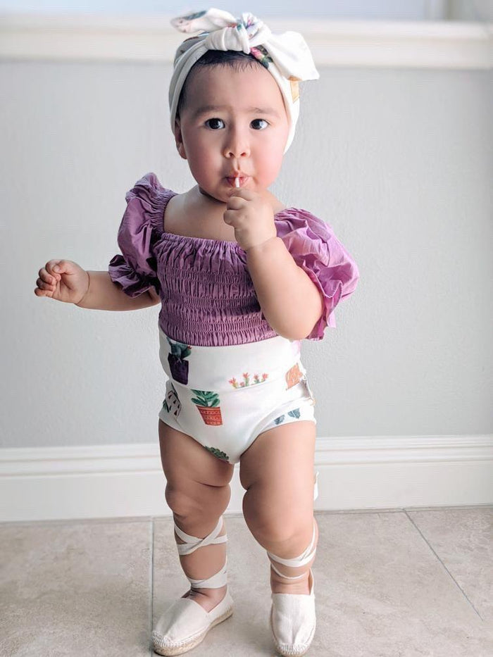 White baby bummies with cute succulent designs, perfect for casual and stylish looks.