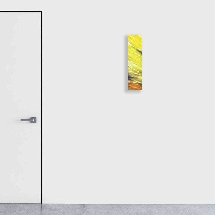 The artwork 'Colored Leaves II' by Takashi Harada features vibrant yellow and orange brushstrokes flowing diagonally across a vertical panel. Abstract leaf-like forms emerge through textured layers of acrylic gesso and cray pastel on Kozo Washi paper, creating a dynamic nature-inspired composition measuring 24x8 inches. By Takashi Harada.