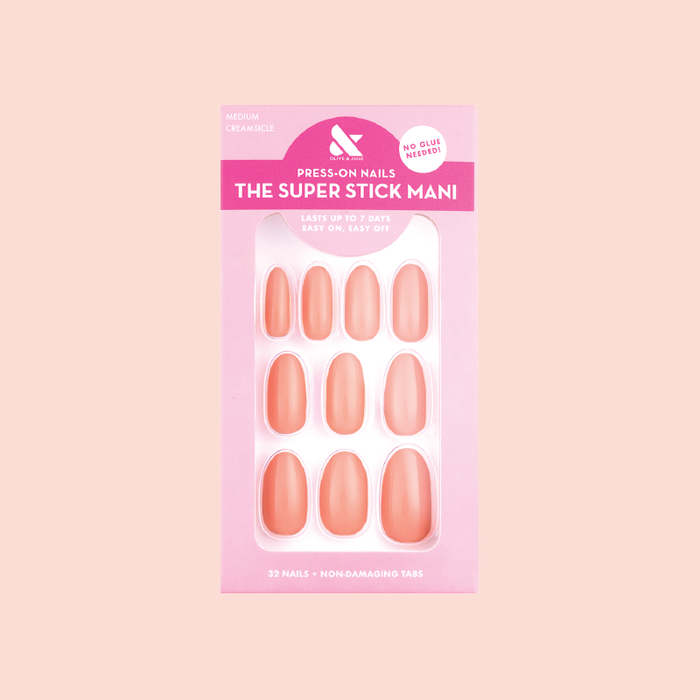 Creamsicle | Medium | Oval - Tab Press-On nails in soft pastel orange with non-damaging tabs in pink packaging on pale background