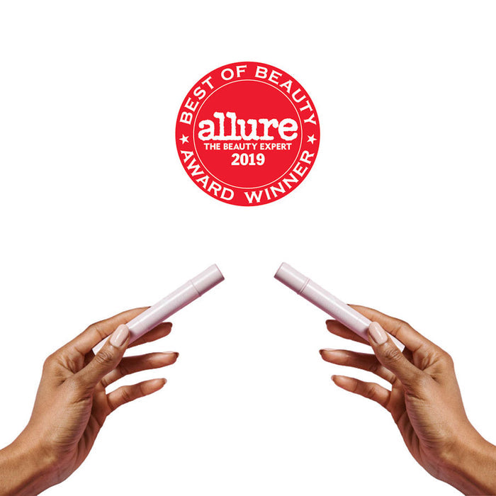 Hands holding two Cuticle Serum Duo pens with Allure Best of Beauty Award 2019 badge on white background
