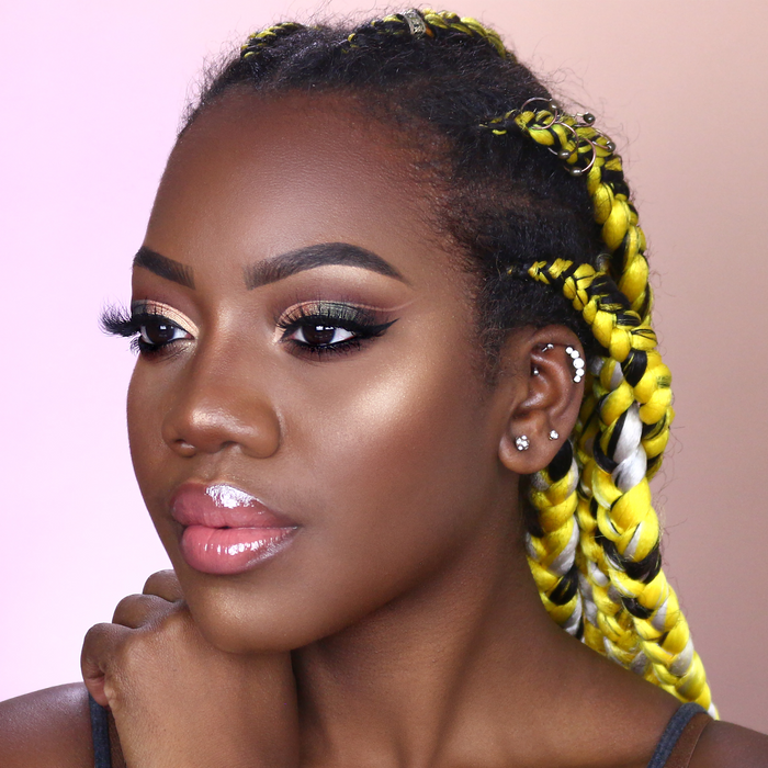 Model wearing Flirty Goddess eyeshadow palette, deep skin tone with braids