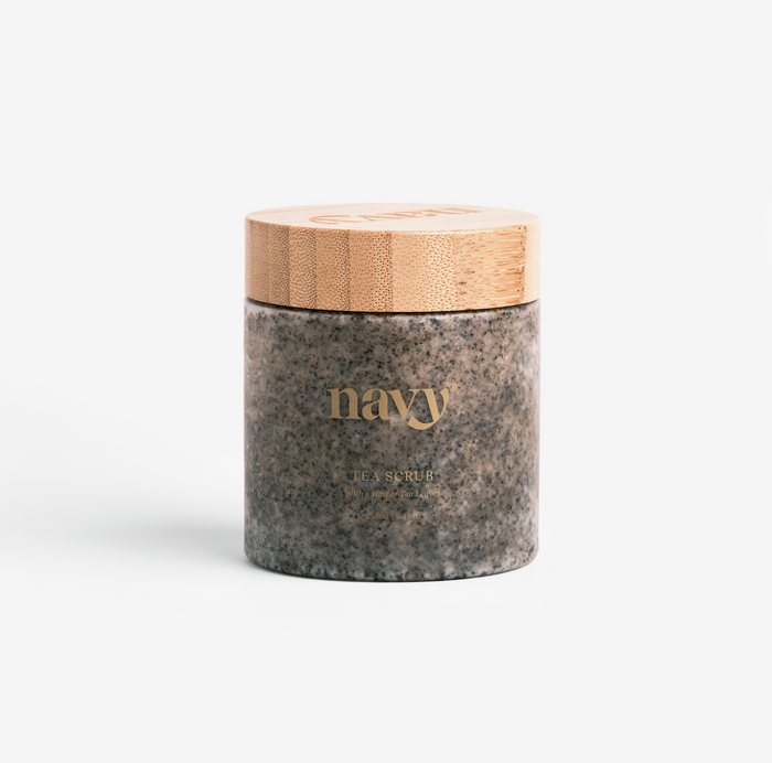 A jar of Navy Scrub exfoliant from the brand NAVY, designed for hands and feet, with a wooden lid on a white background.