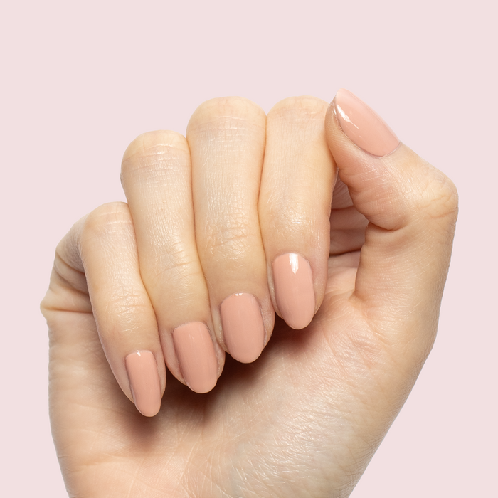 HZ - Gel soft rosy neutral gel polish manicure on almond-shaped nails against pale pink background
