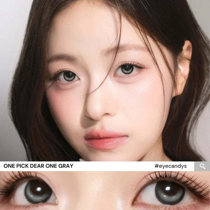 Model wearing i-Girl One Pick Dear One Grey contact lenses from EyeCandys, featuring cool grey iris color, weighted non-rotating design, subtle eye-widening effect, and all-day comfort with silicone hydrogel