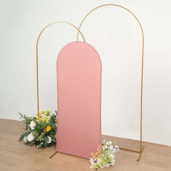 Pink fabric backdrop with gold arches and floral arrangements.