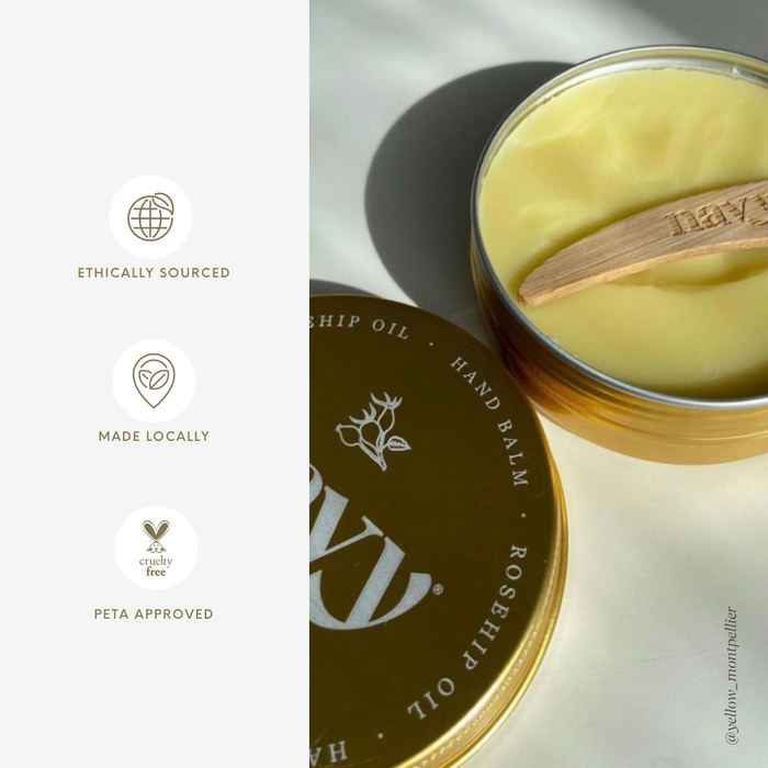 Hand balm in a tin with a wooden applicator on a light background, featuring ethical sourcing and approval icons.