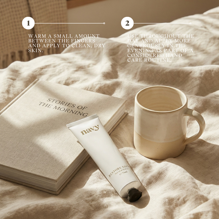 Skincare tube, mug, and book on a textured surface with text overlay. Navy Salve Hand Balm