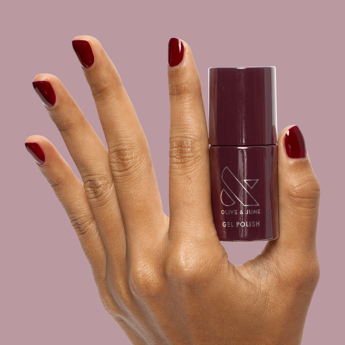 Obsessed - Gel held by hand with matching dark ruby red gel polish for a rich, durable mani by Olive and June
