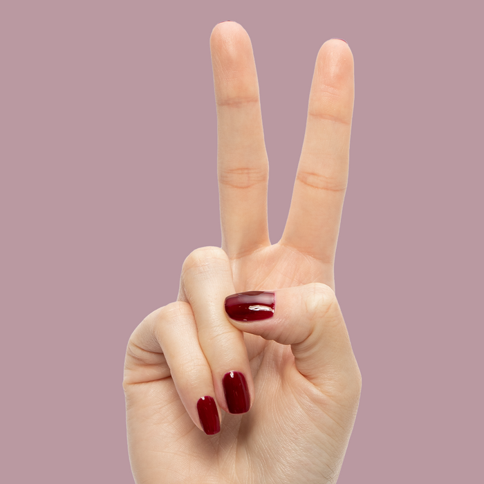 Obsessed - Gel displayed on manicured nails in a deep rich red shade for a glossy long-lasting mani by Olive and June