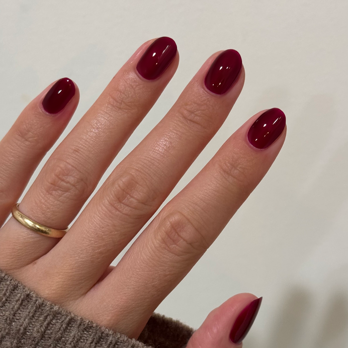 Obsessed - Gel shown on natural nails in a glossy deep ruby red for a rich long-lasting gel manicure by Olive and June