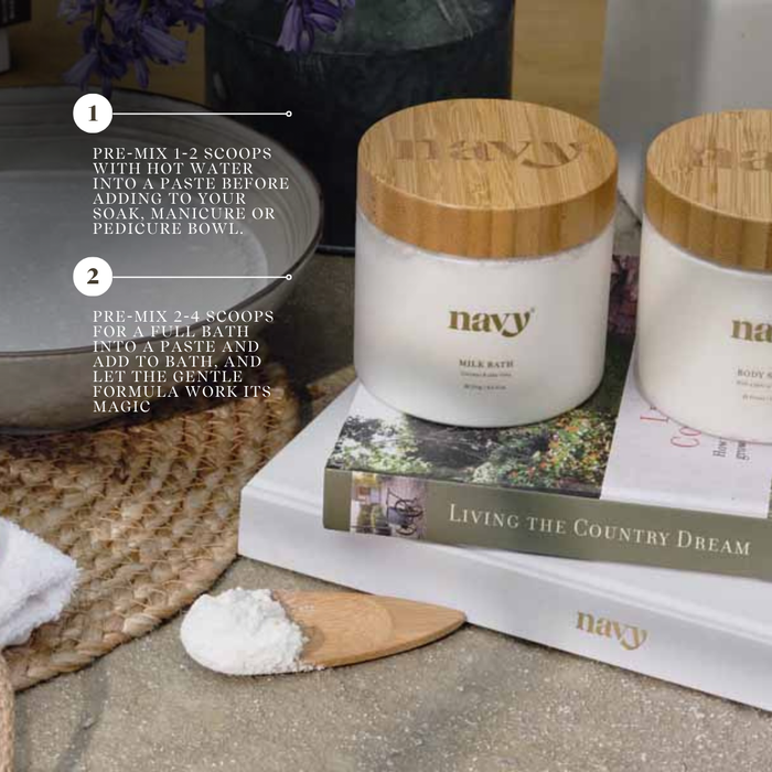 Navy Bath Milk stacked on books.
1) Pre-mix 1-2 scoops with hot water into a paste before adding to your soak, manicure or pedicure bowl. 
2) Pre-mix 2-4 scoops for a full bath into a paste and add to bath, and let the gentle formula work its magic.