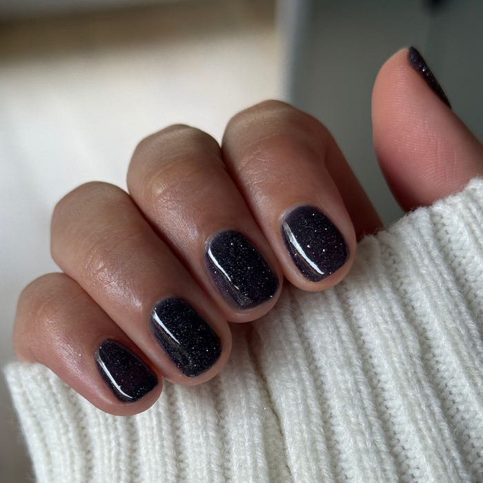 Fingernails painted with Out Past Curfew Gel showing deep blue-black gel polish with subtle flash glitter for a sleek mani