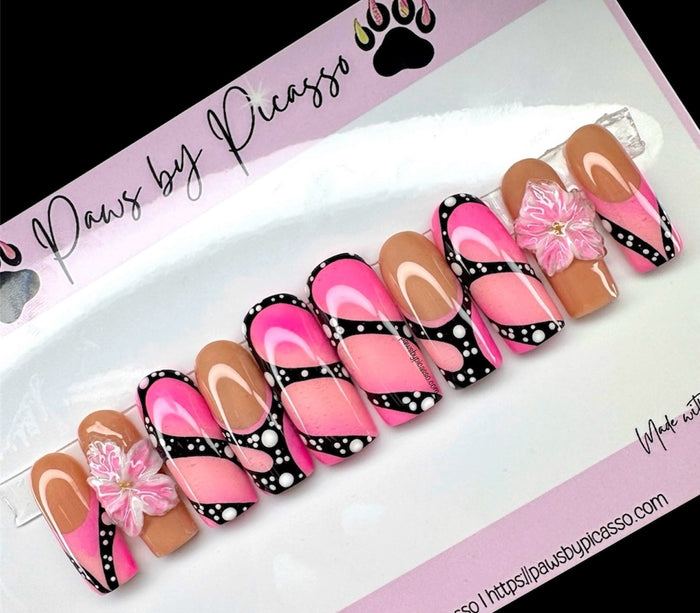 Set of decorative false nails with pink, brown, and black designs on a white tray with 'Paws by Picasso' branding.
