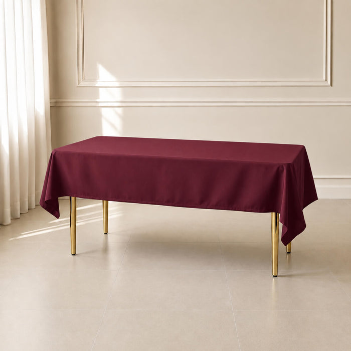 Burgundy polyester rectangle tablecloth on a table in a bright room.