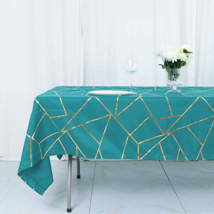 Teal tablecloth with gold geometric pattern on a dining table.
