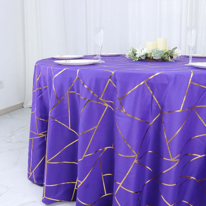 Purple tablecloth with gold geometric pattern on a round table.