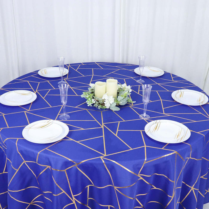 Round blue tablecloth with geometric gold design, set for dining.