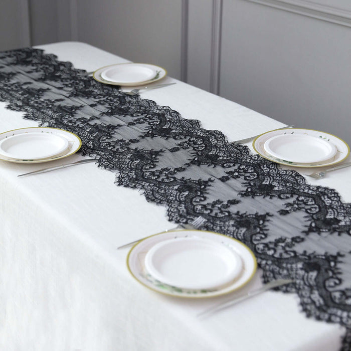 Black lace table runner on a white table with plates