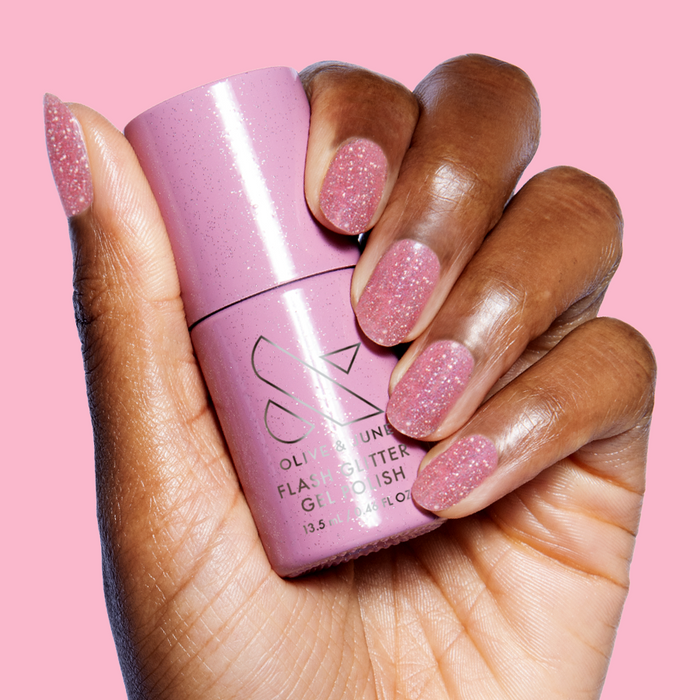 Hand holding Rosé Rhymes with Partay Gel bottle with sparkly cool-toned pink flash glitter gel polish manicure