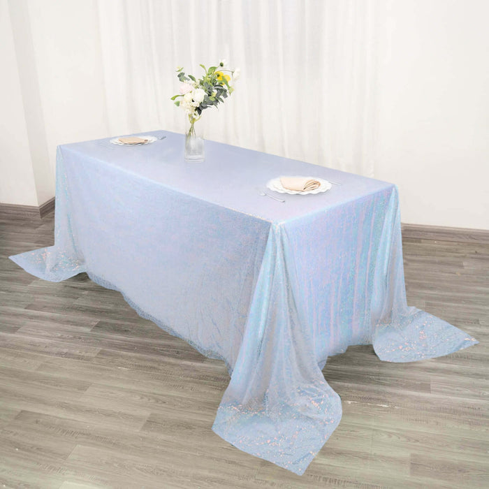 Iridescent tablecloth draped elegantly over a table with floral centerpiece.