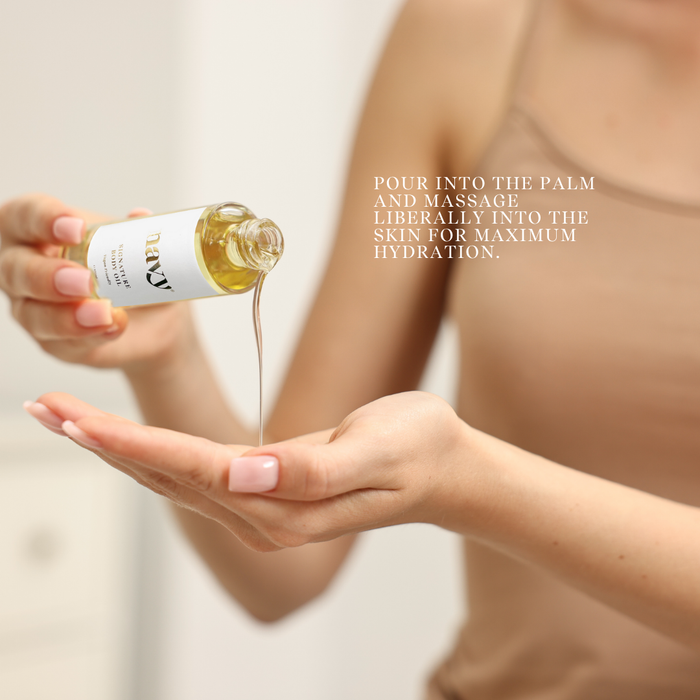 Person pouring oil from a bottle into their palm with a blurred background