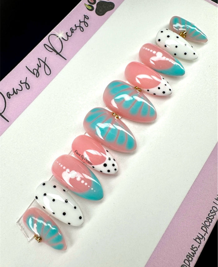 Set of decorative false nails with pink, turquoise, and white designs on a branded card.