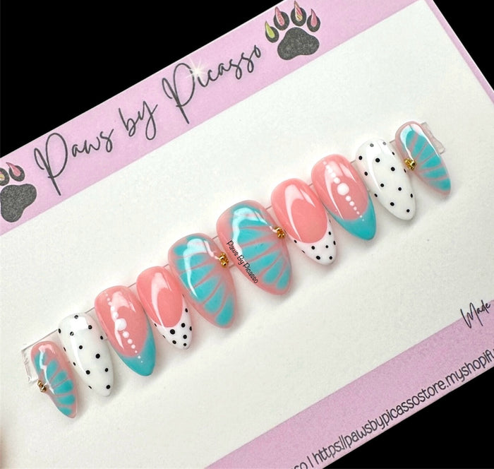 Set of decorative false nails with pink, turquoise, and white design on a 'Paws by Picasso' branded card.