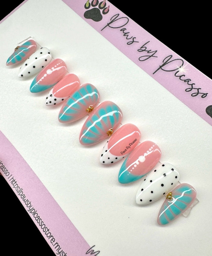 Set of decorative nails with pink, turquoise and white design on a 'Paws by Picasso' branded card.