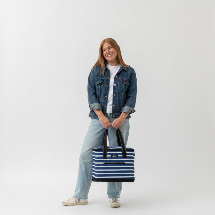 Person holding a striped bag against a white background