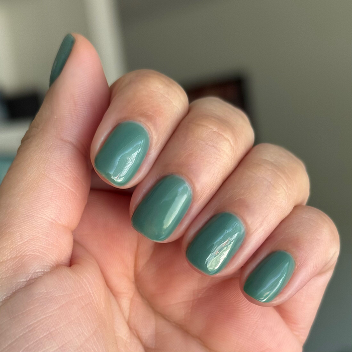 Close-up of short rounded nails painted in Still Life of Flowers - Gel mossy green gel polish on natural skin tone