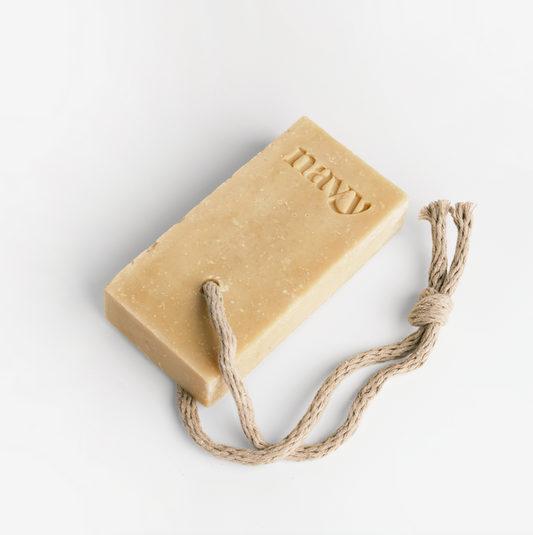 A beige soap bar with 'NAVY' embossed on it, attached to a rope for hanging. Hint of Navy signature scent