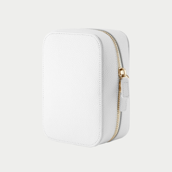 White jewelry box with a gold zipper on a light gray background