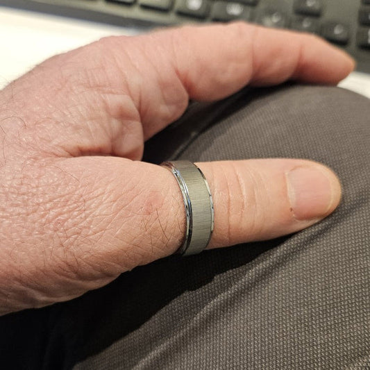 8mm Silver Tungsten Carbide Ring with cross satin finish and polished edges on finger.